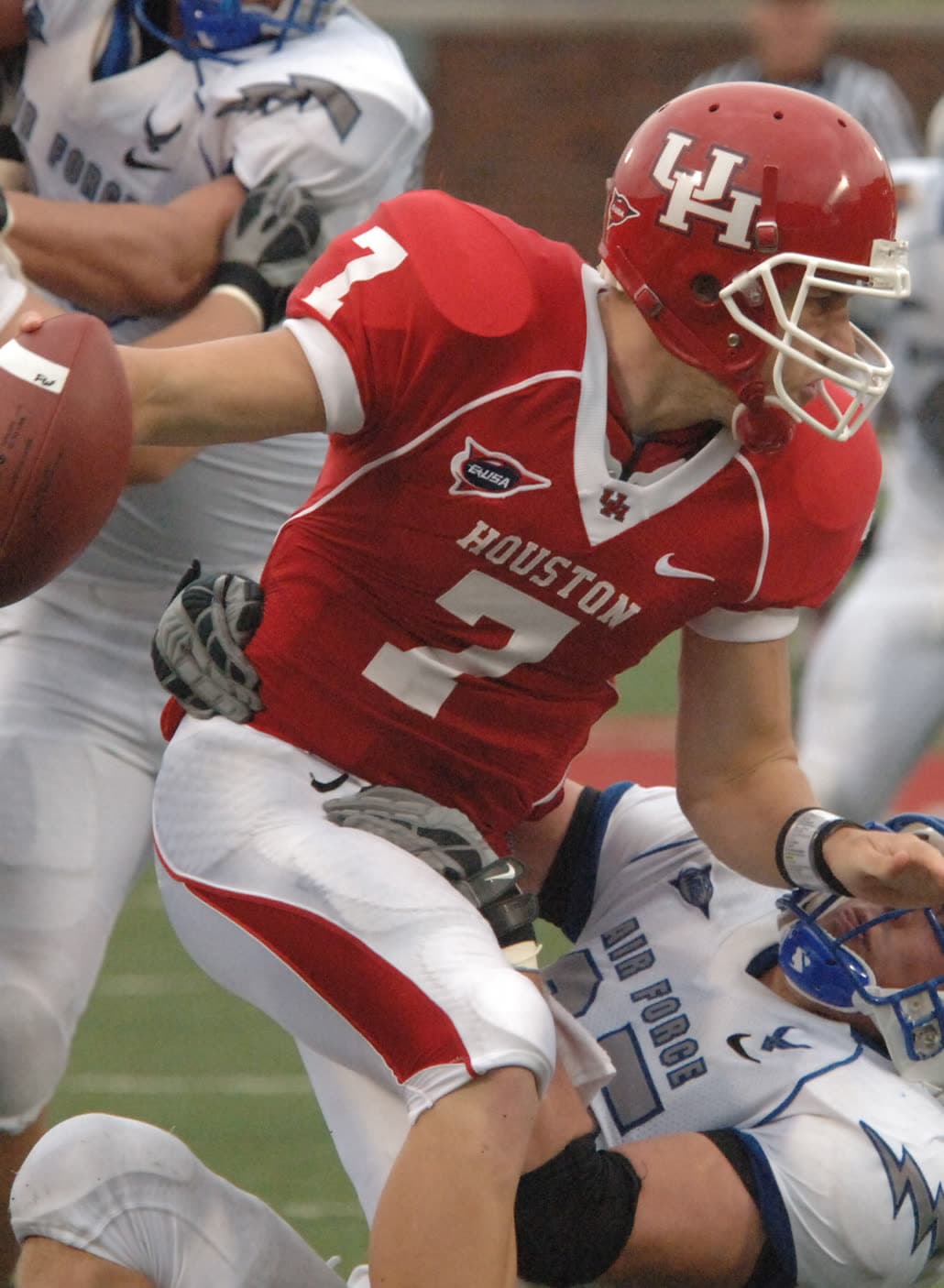 Case Keenum in a red Houston Cougars uniform, number 7, dropping back to pass