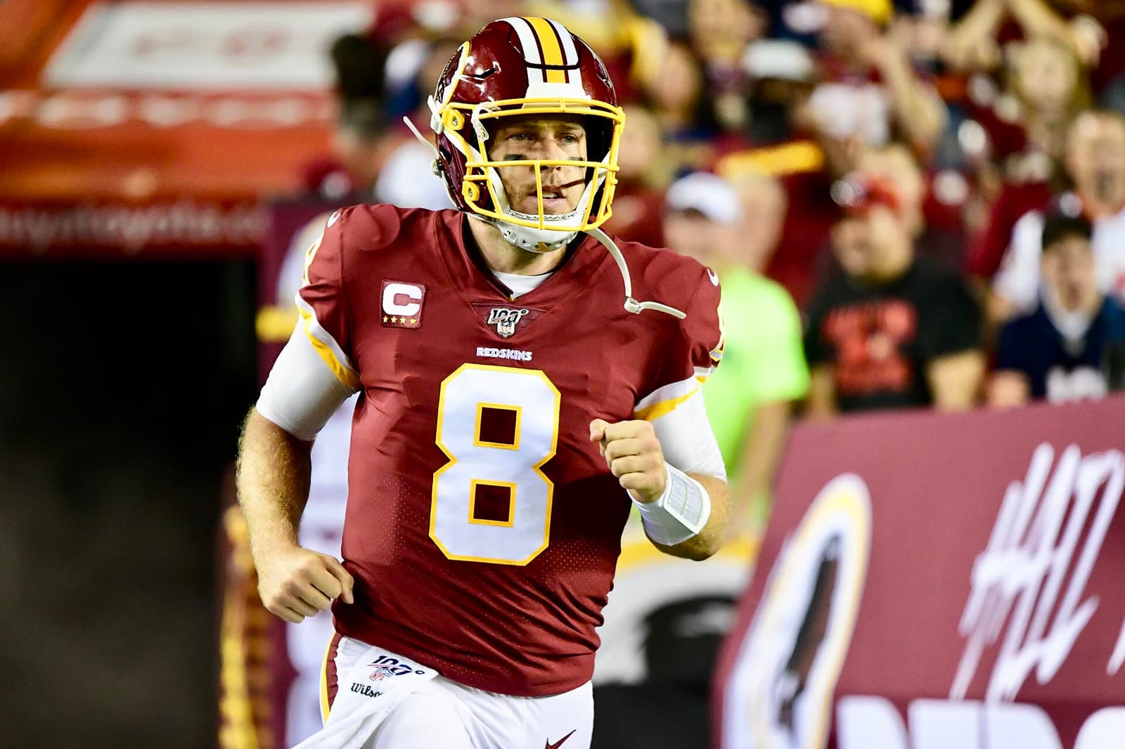 Case Keenum in a Washington uniform, jogging onto the field under stadium lights