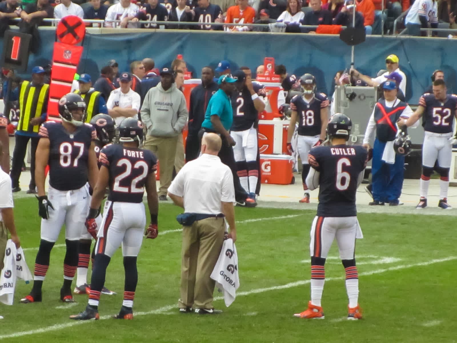 The Chicago Bears offense, Jay Cutler in No. 6 and Matt Forte in No. 22, standing on the Soldier Field grass during a TV timeout.
